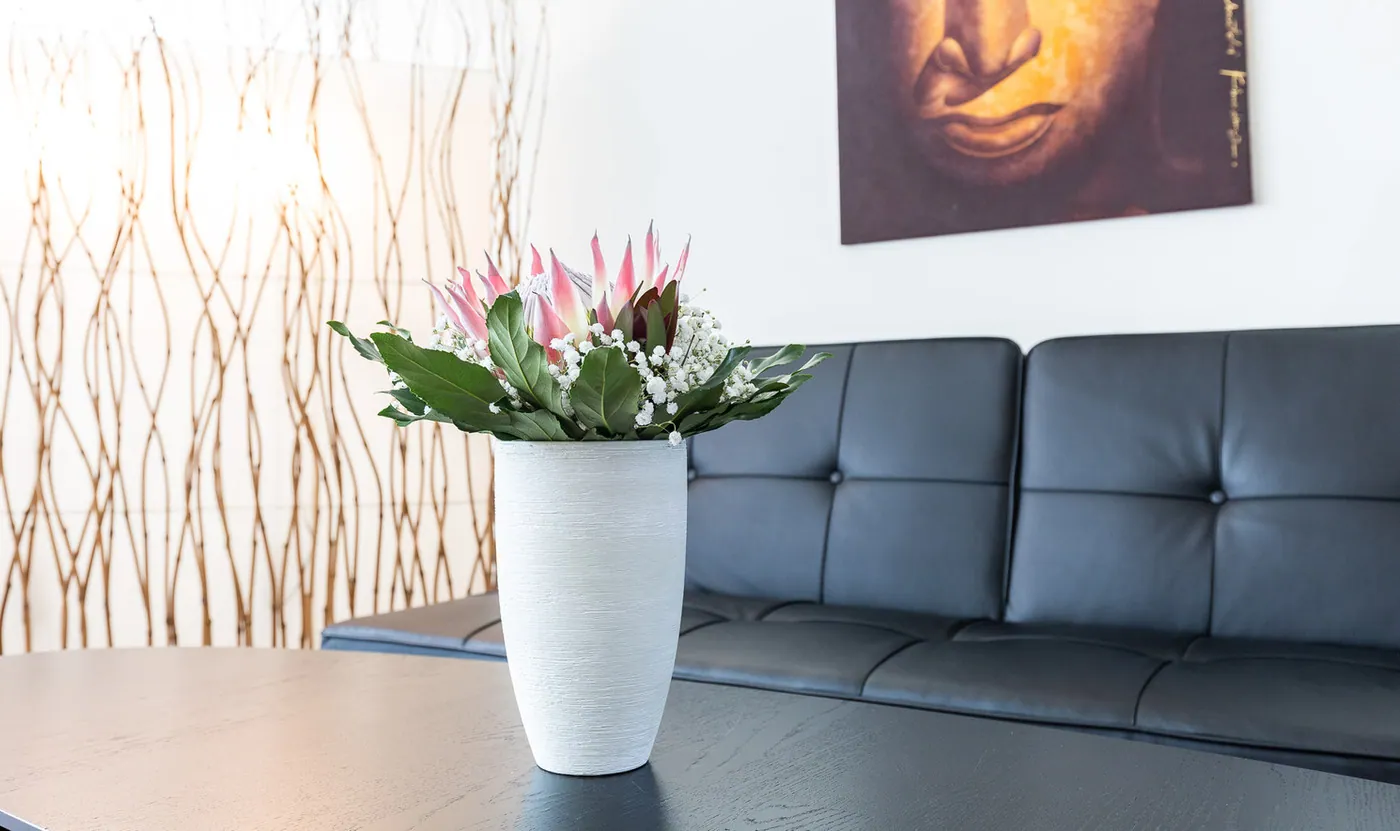 Wartebereich mit Ledersofa und Blumen
